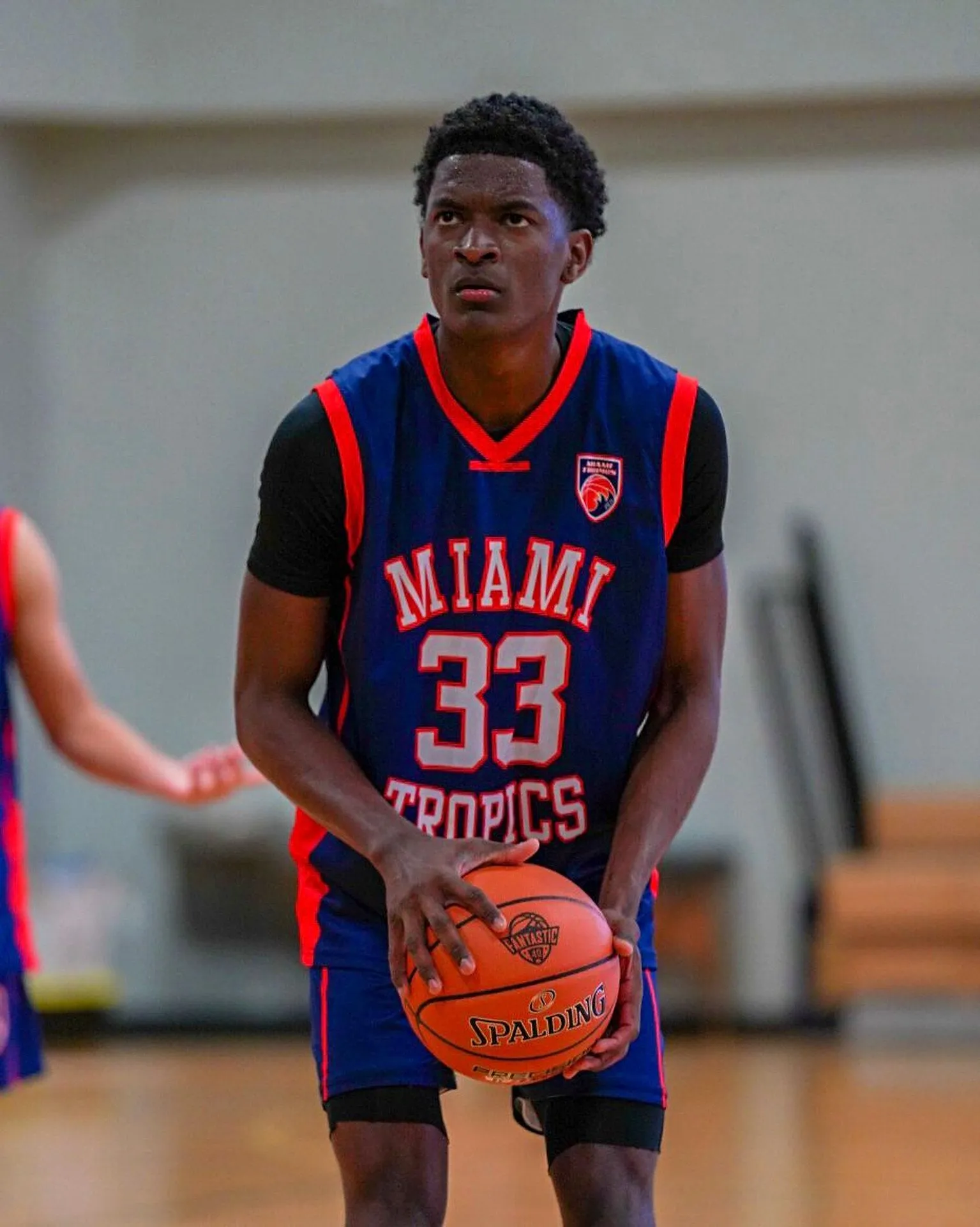 Kaleb Myers holding a Spalding basketball in a Miami Tropics uniform